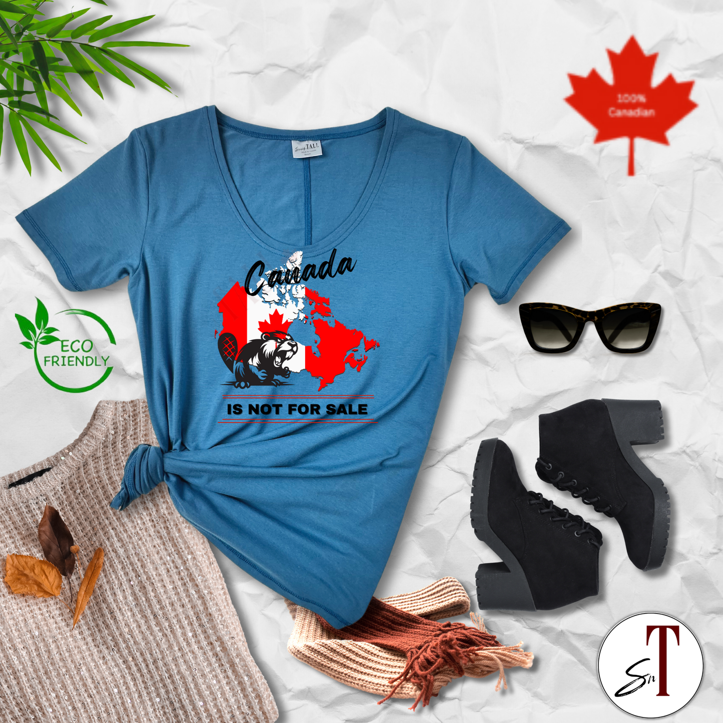 Flat lay of "Canada Is Not for Sale" t-shirt with complementary accessories, bold Canadian-made tee styled with layered pieces and patriotic details.